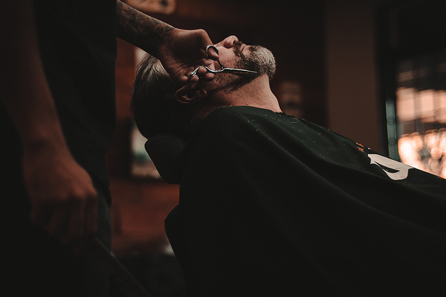 A man who arranges his beard in a barber shop