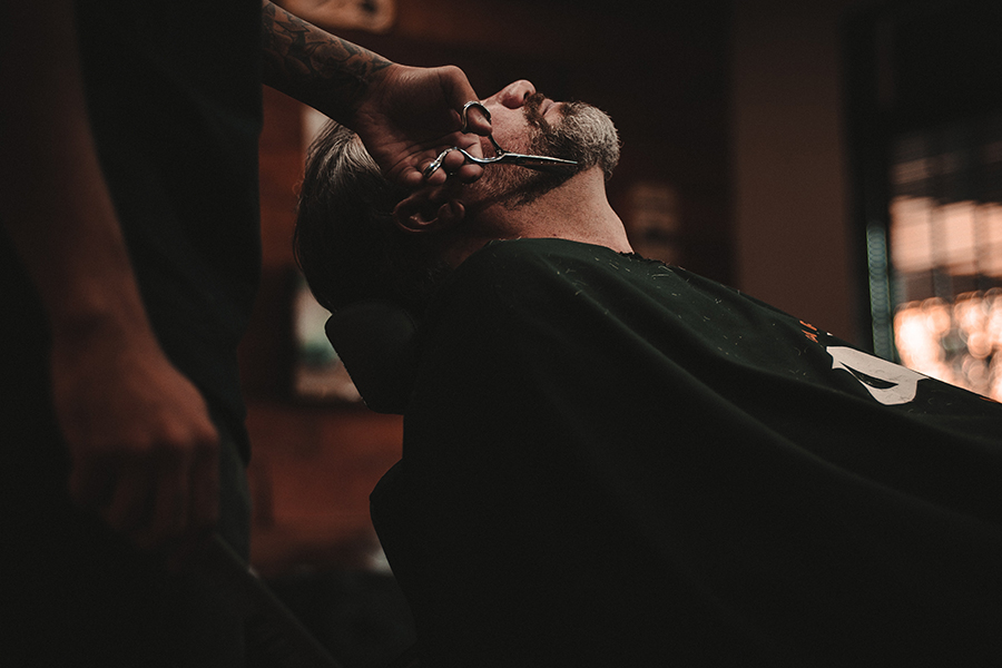 Why_go_to_the_barber A man who arranges his beard in a barber shop